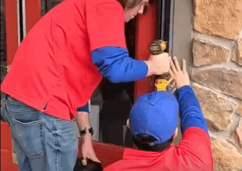 Continuous hinge installation on an aluminum storefront door in Fayetteville.
